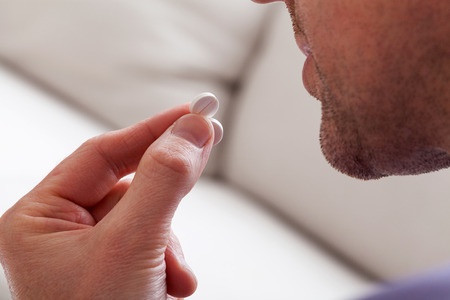 man in middle age taking  pill